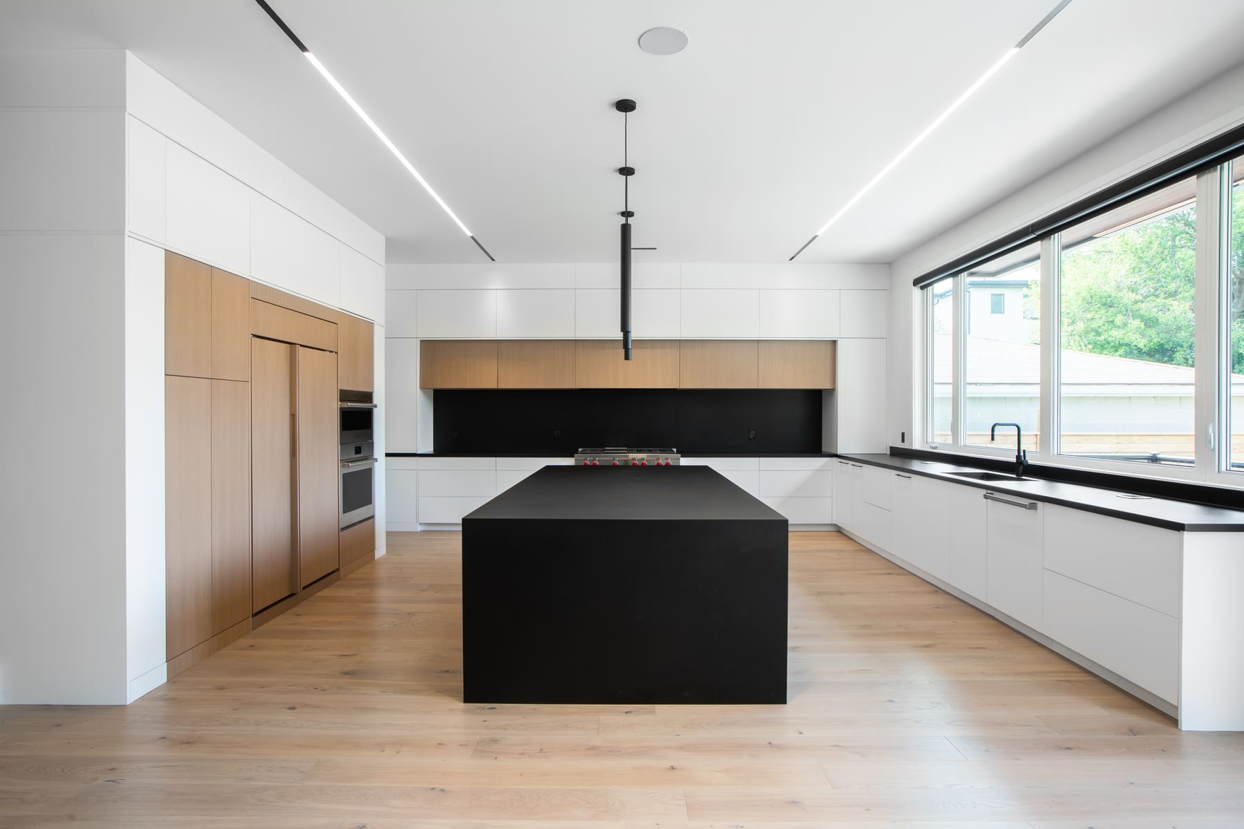 Kitchen with dark island and ceiling linear lights