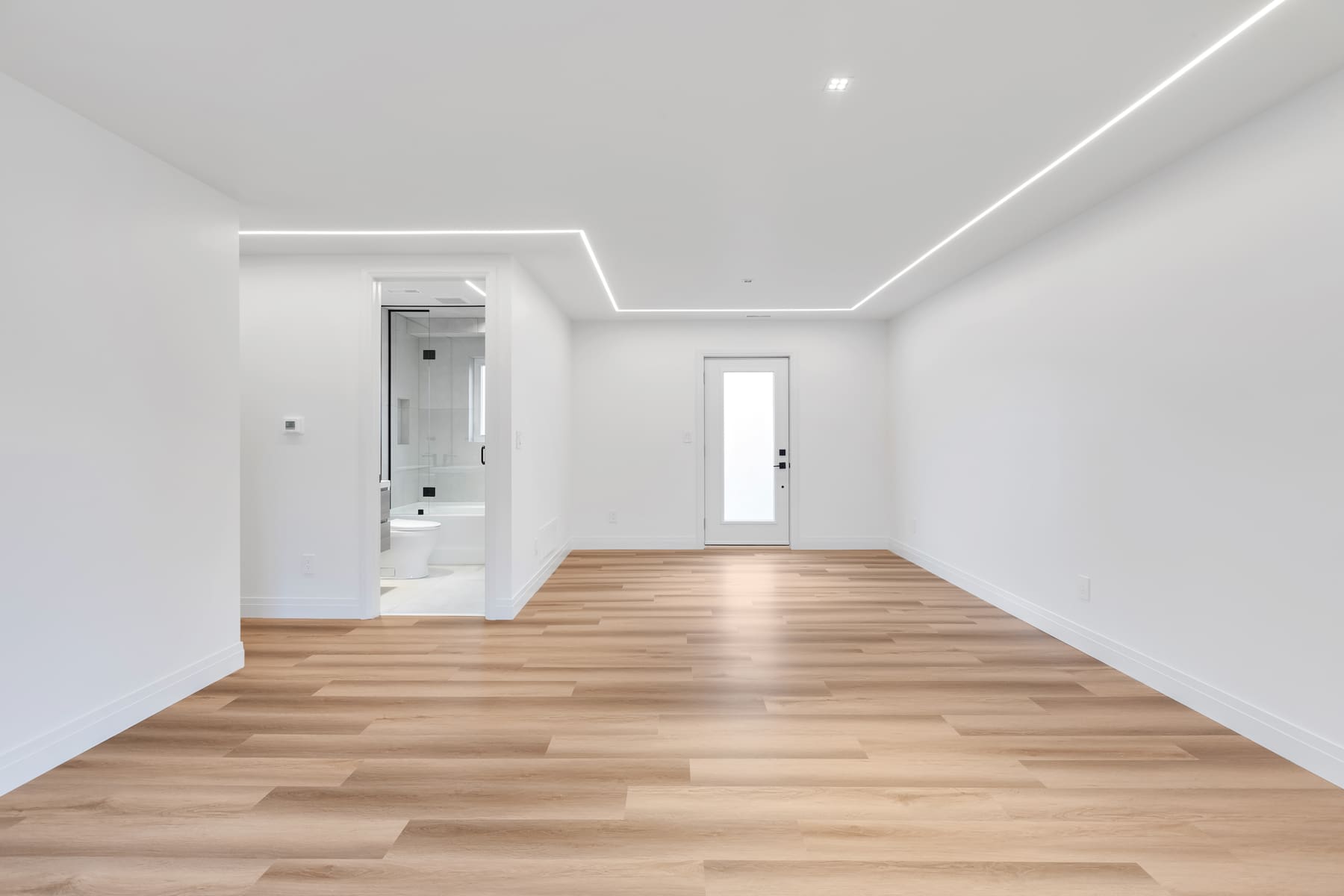 White room with geometric ceiling lighting